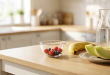 Gut verträgliche Lebensmittel bei Fructoseintoleranz: Banane, Honigmelone und Beeren auf einer hellen Küchenarbeitsplatte